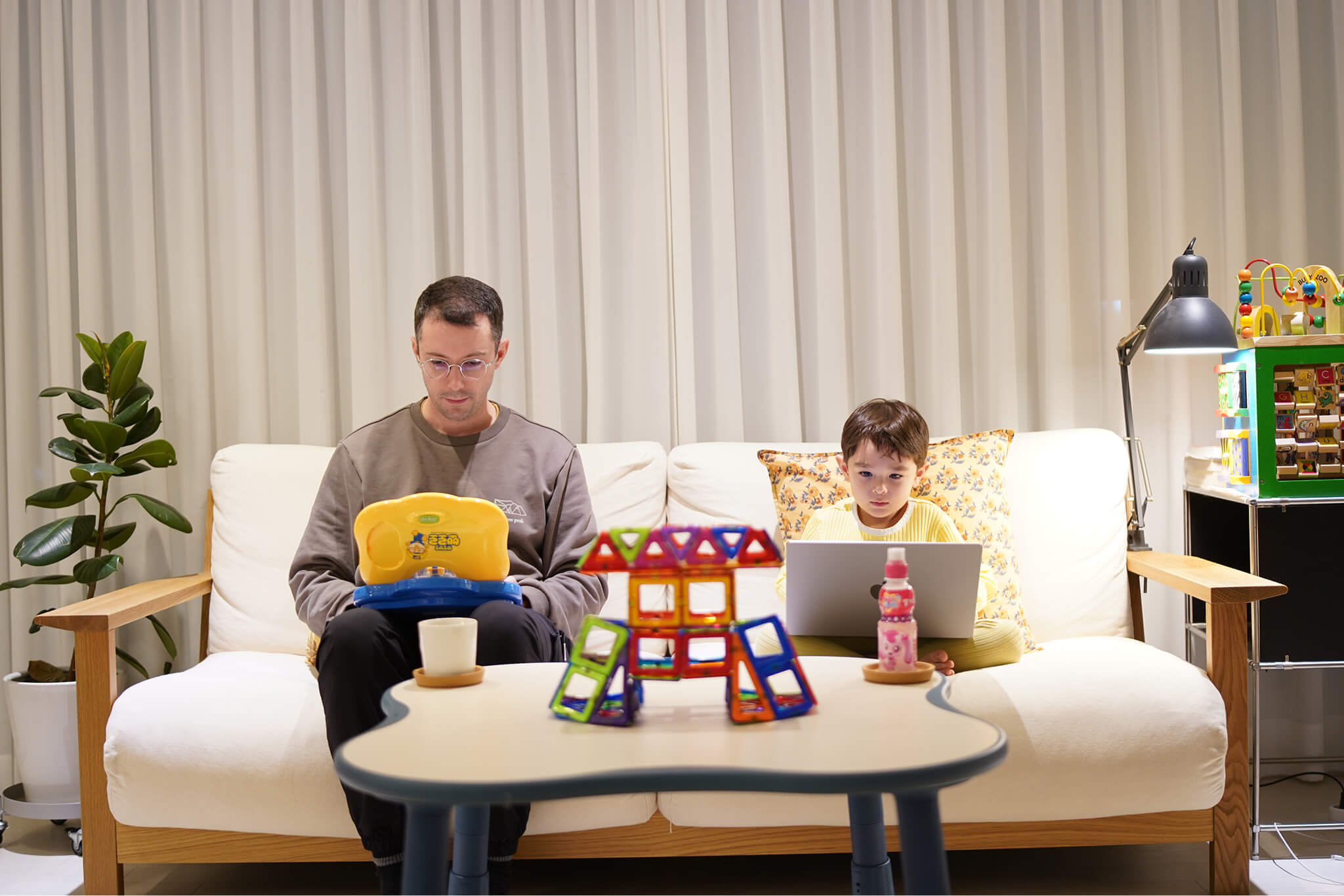 A baby sitting in a baby seat surrounded by colorful sticky notes on a white cabinet
