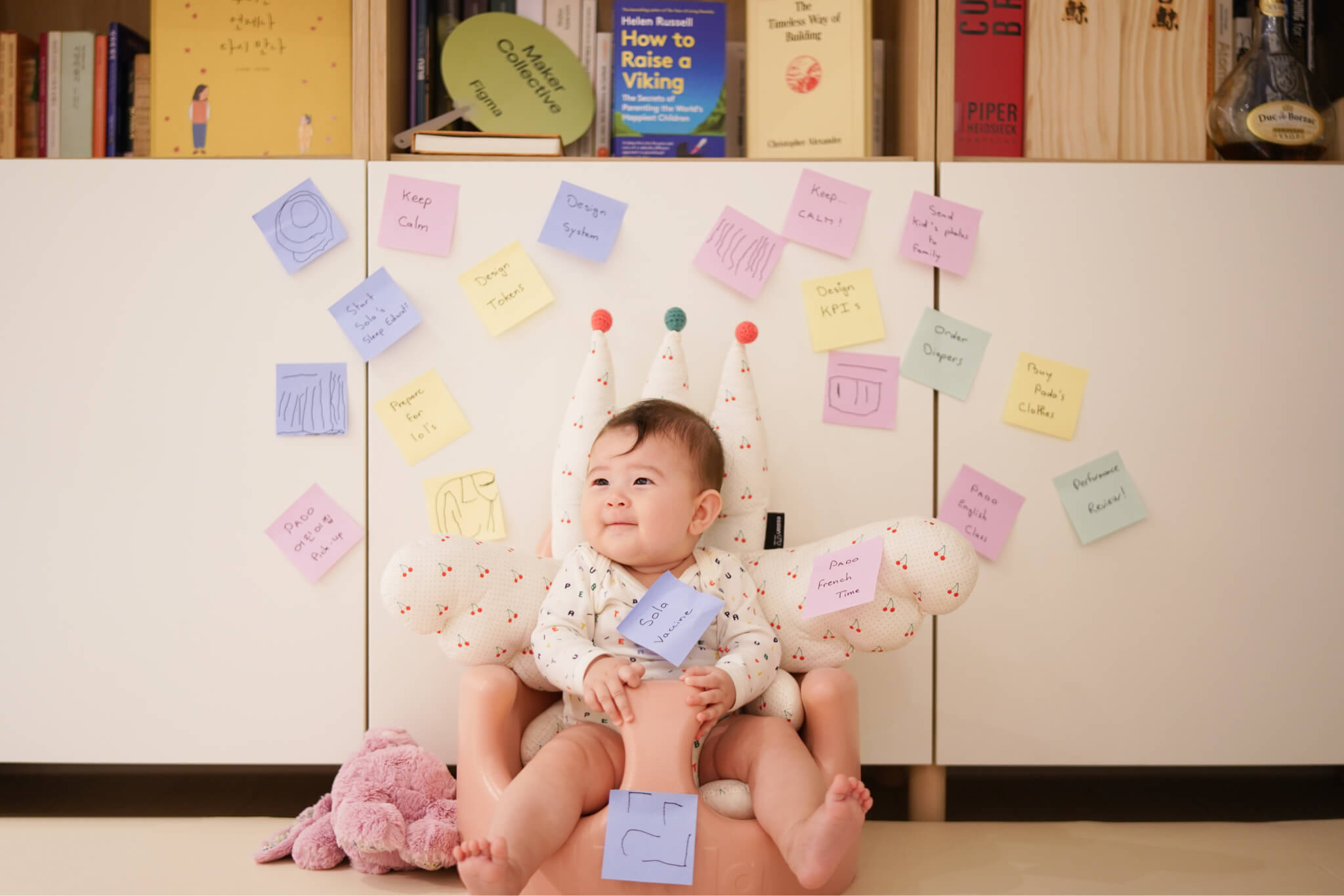 A man and young boy sitting on a sofa with electronic devices and toys on a table